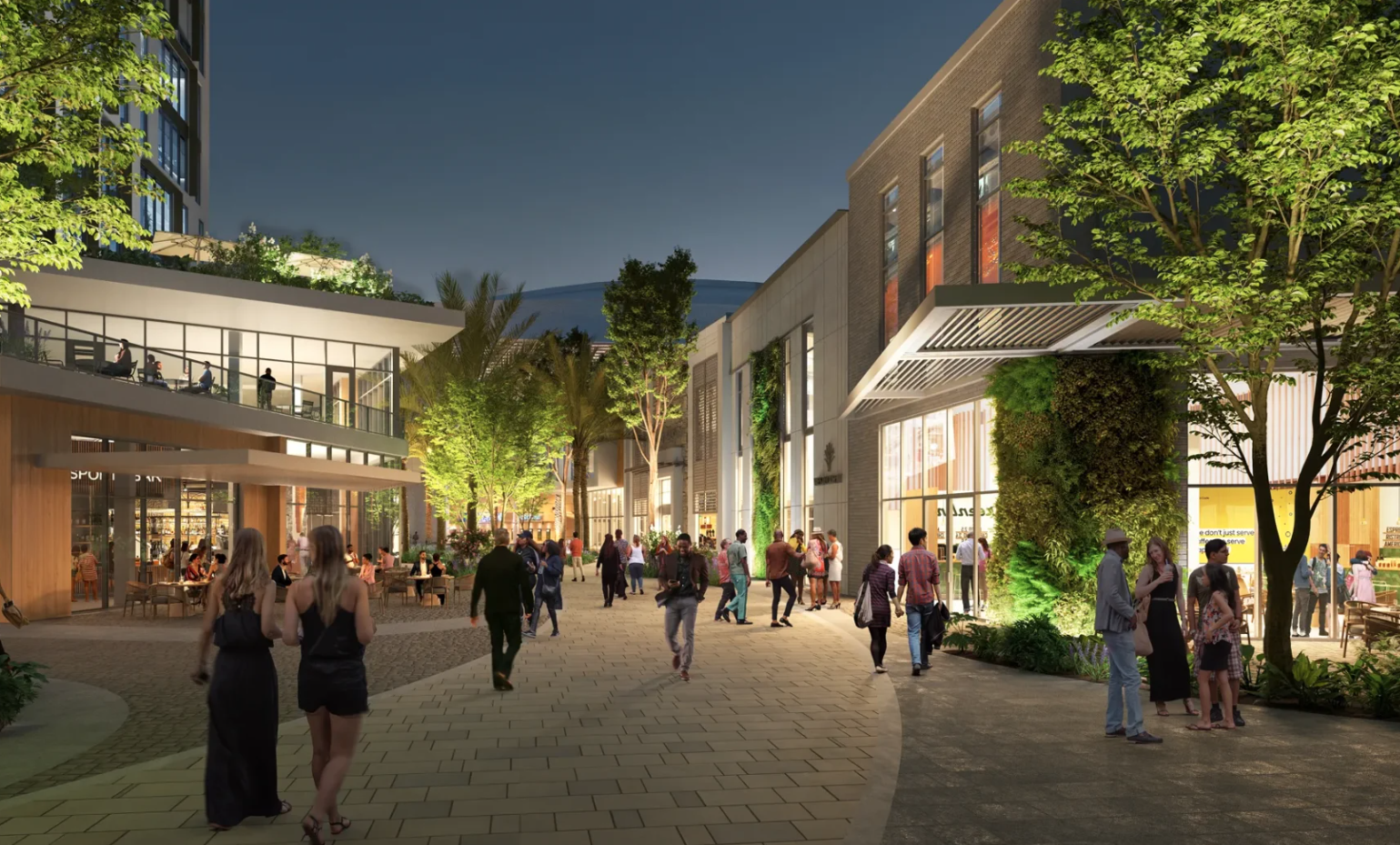 Village Green at night with people enjoying the walkways and shops
